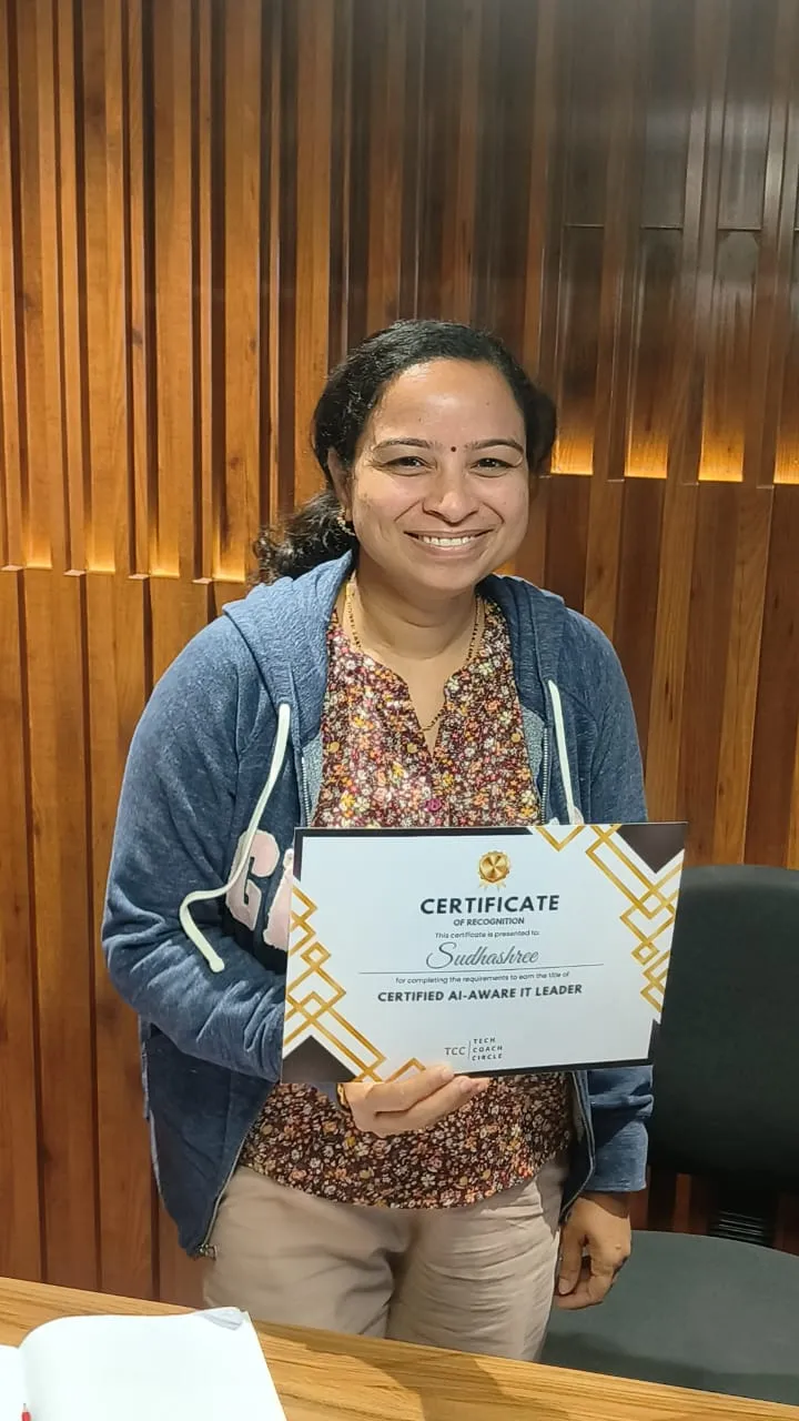 A graduate holding her Certified AI-Aware IT Leader certificate
