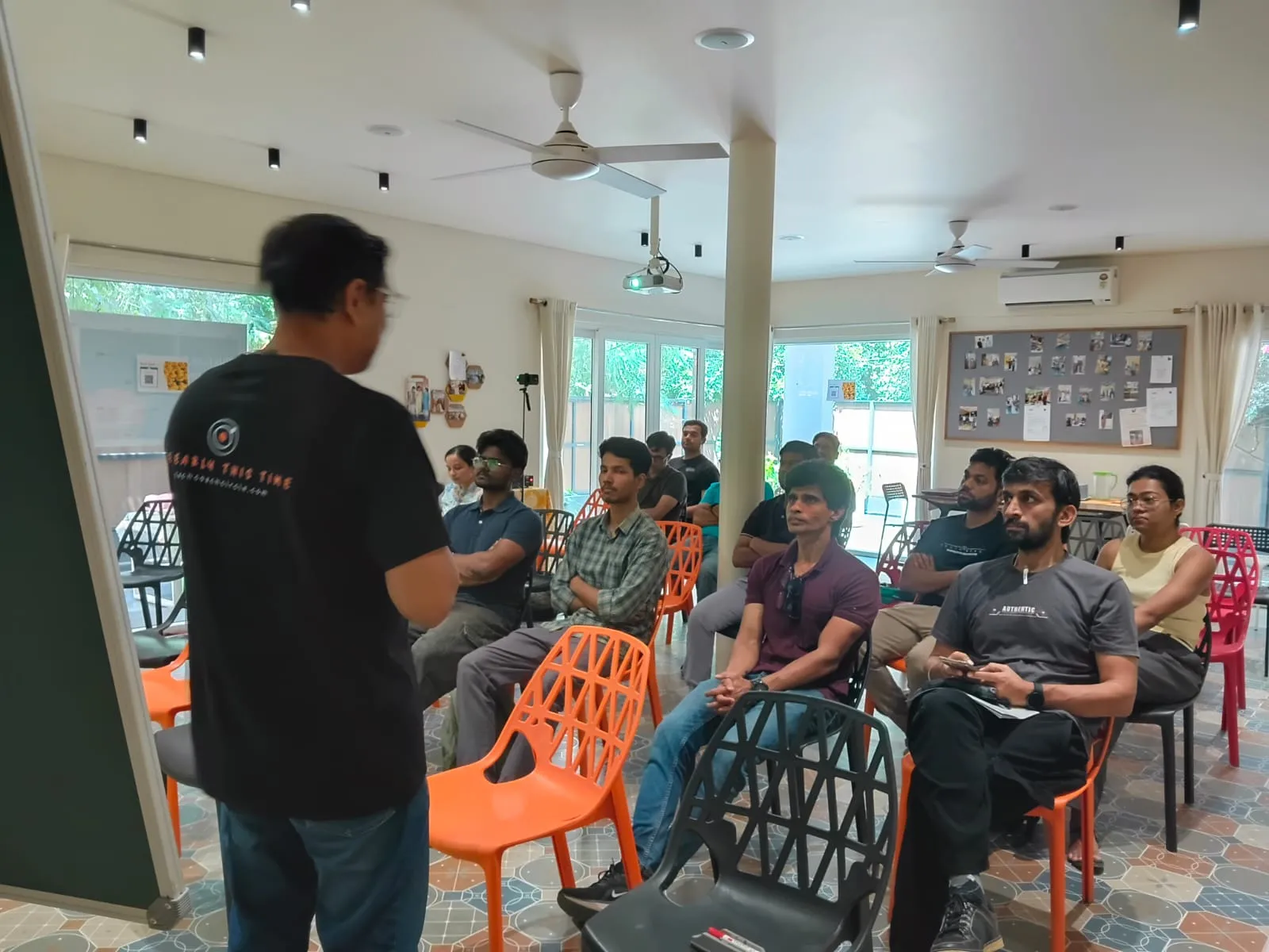 A speaker addressing a seated audience at the Quantum Circle in a bright Bangalore venue